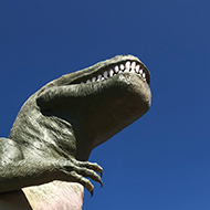 Cabazon dinosaur with blue sky and palm tree