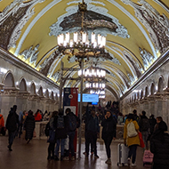 A tube station with bright yellow Walla, mosaics and chandeliers.