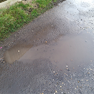 Puddle in a dirt track in the shape of guitar