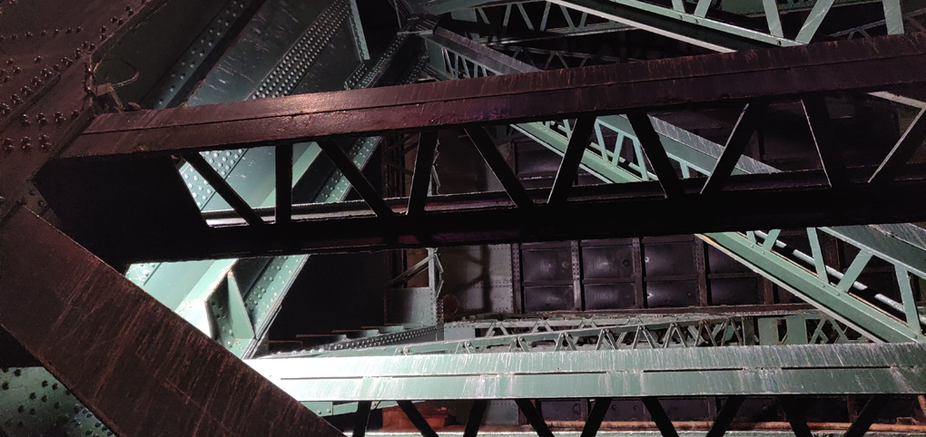 Looking up into the criss cross of structural steel supporting the Tyne Bridge in Newcastle