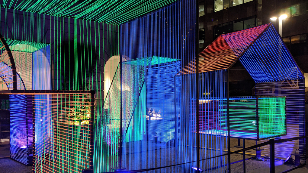 A set of geometric shapes and structures covered in colourful, flourescent wires.