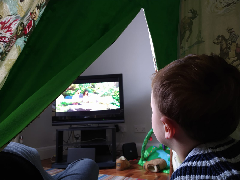 boy watching TV in an indoor tepee