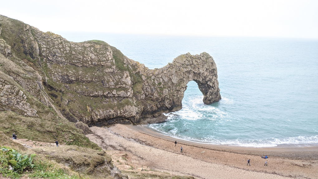 Durdle Door, a natural limestone arch, reaching out into the sea in Dorset.