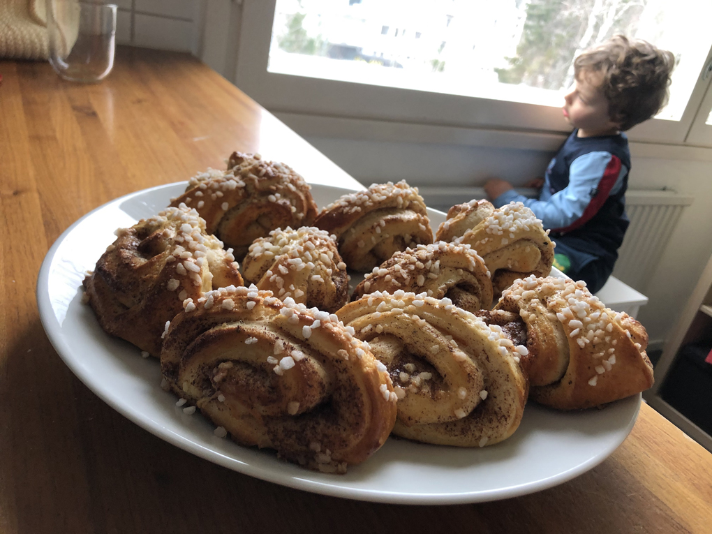 Tray of baked things with a child by a window in the background.