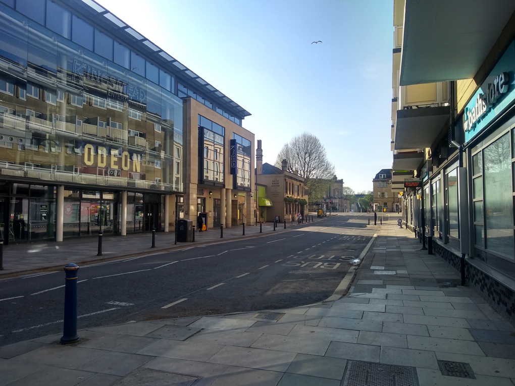 Deserted road with cinema complex on the left and pub in the distance