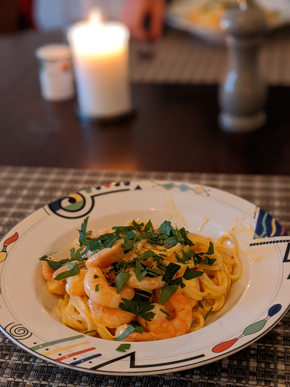 Shrimp Alfredo pasta on table with candle