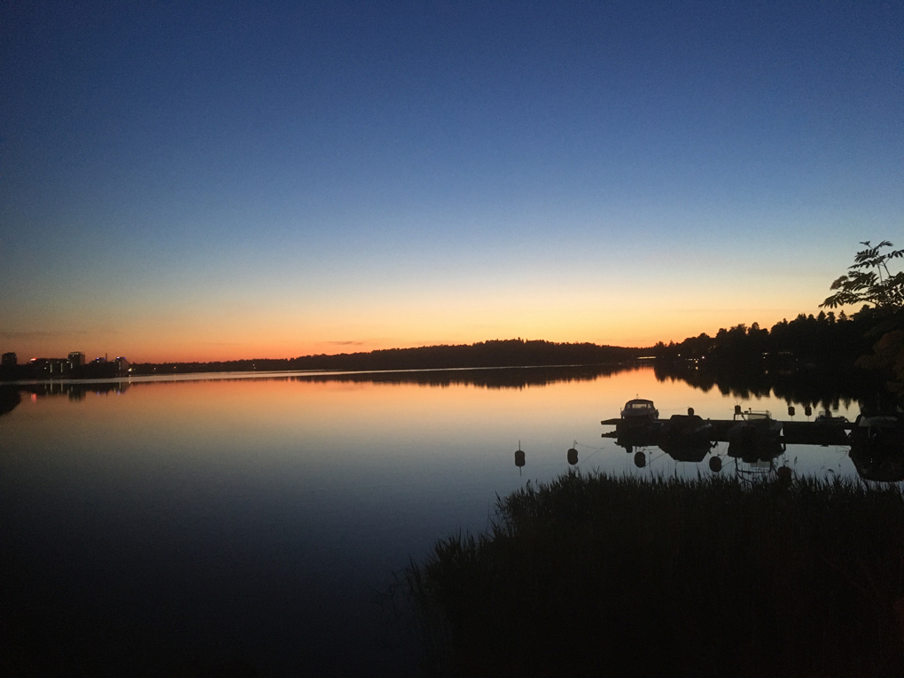 Sun setting in the horizon beyond a bay.