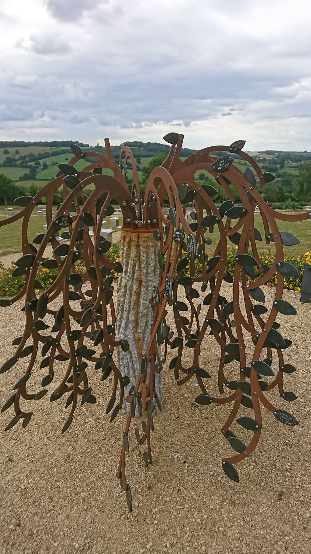 A beautiful sculpture of a weeping willow tree made of copper and other metal. It stands on a high point in a beautifully laid out cemetery with a lovely view of the countryside. Its leaves each have the name of a person to be remembered. I took this photo as a memorial for all those who have died of The Corona Virus throughout this awful and strange year.