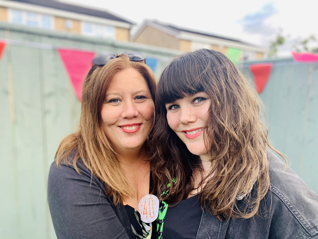 Two sisters hugging in the garden.