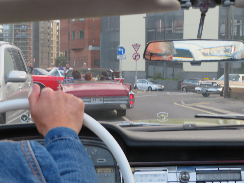 We see through the windscreen of a '59 Ford to a 63 Cadillac and '59 Plymouth in the middle distance, as they cruise around Redhill Surrey