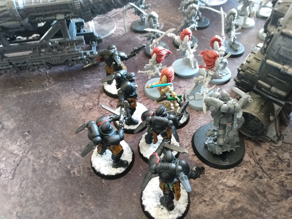 Some painted space marines assault some unpainted eldar