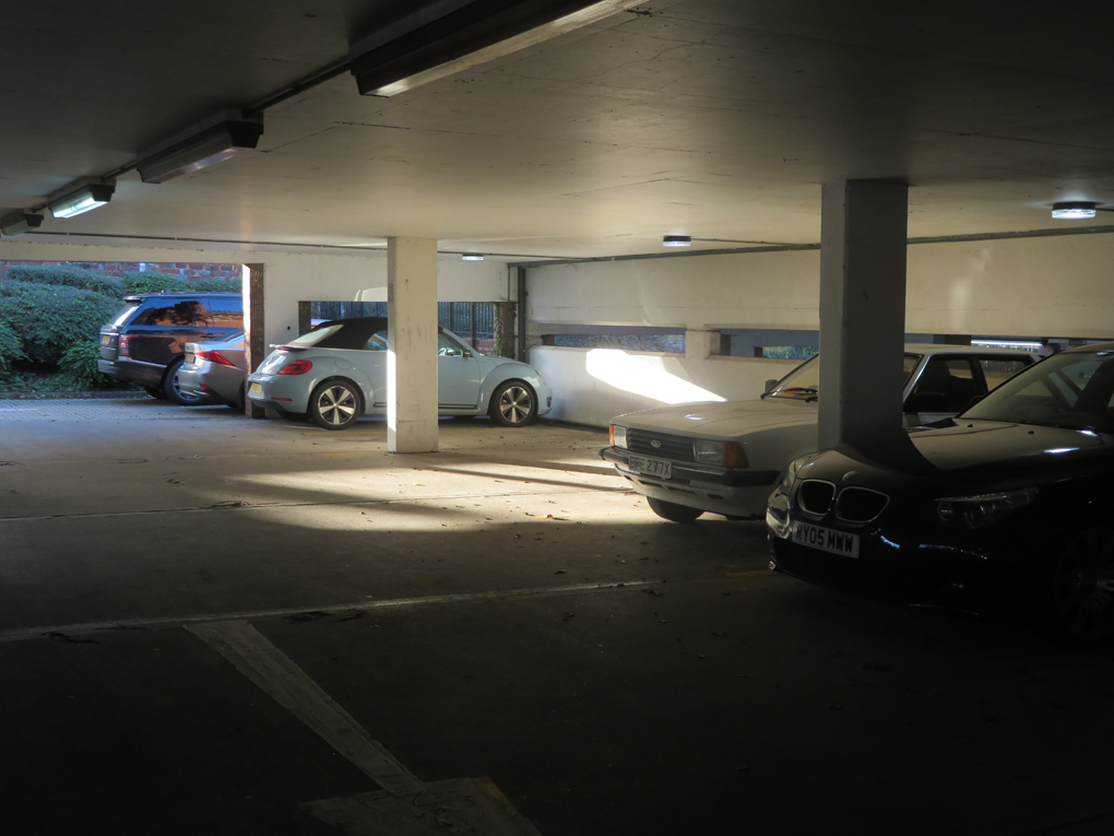 A shaft of late Autumn sunlight brightly illuminates a spot in an a below ground car park in St Martins car park Dorking