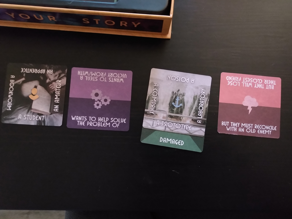 5 cards are laid out expressing elements of a story - a student - wants to help solve the problem of - a damaged prototype - but they must reconcile with an old enemy