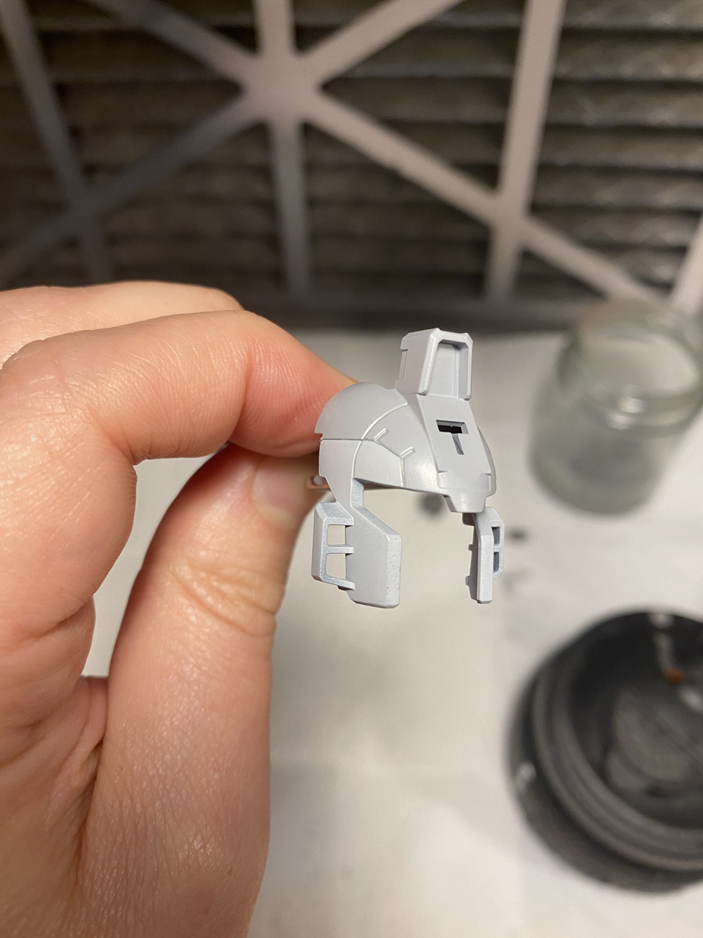 A piece of a Gunpla kit’s head, painted in two shades of gray to accent the head crest.