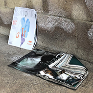 Two dog-eared, water damaged magazines on the floor of an empty garage