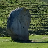 Large stones stand in a pleasant, green field at Avebury village in Wiltshire