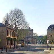 Deserted road with cinema complex on the left and pub in the distance