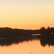 Sun setting in the horizon beyond a bay.