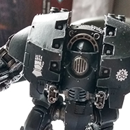 A warhammer miniature painted in the black of the Iron Hands legion