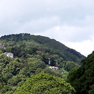 A rocky river flowing through a densely forested valley in southern England