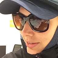 Woman wearing a cycling helmet, cap and sunglasses.