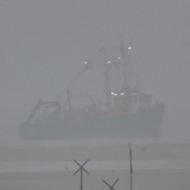 We see acrosss the marshes to a Trawler fishing close to the entrance of Thornham harbour, North Norfolk