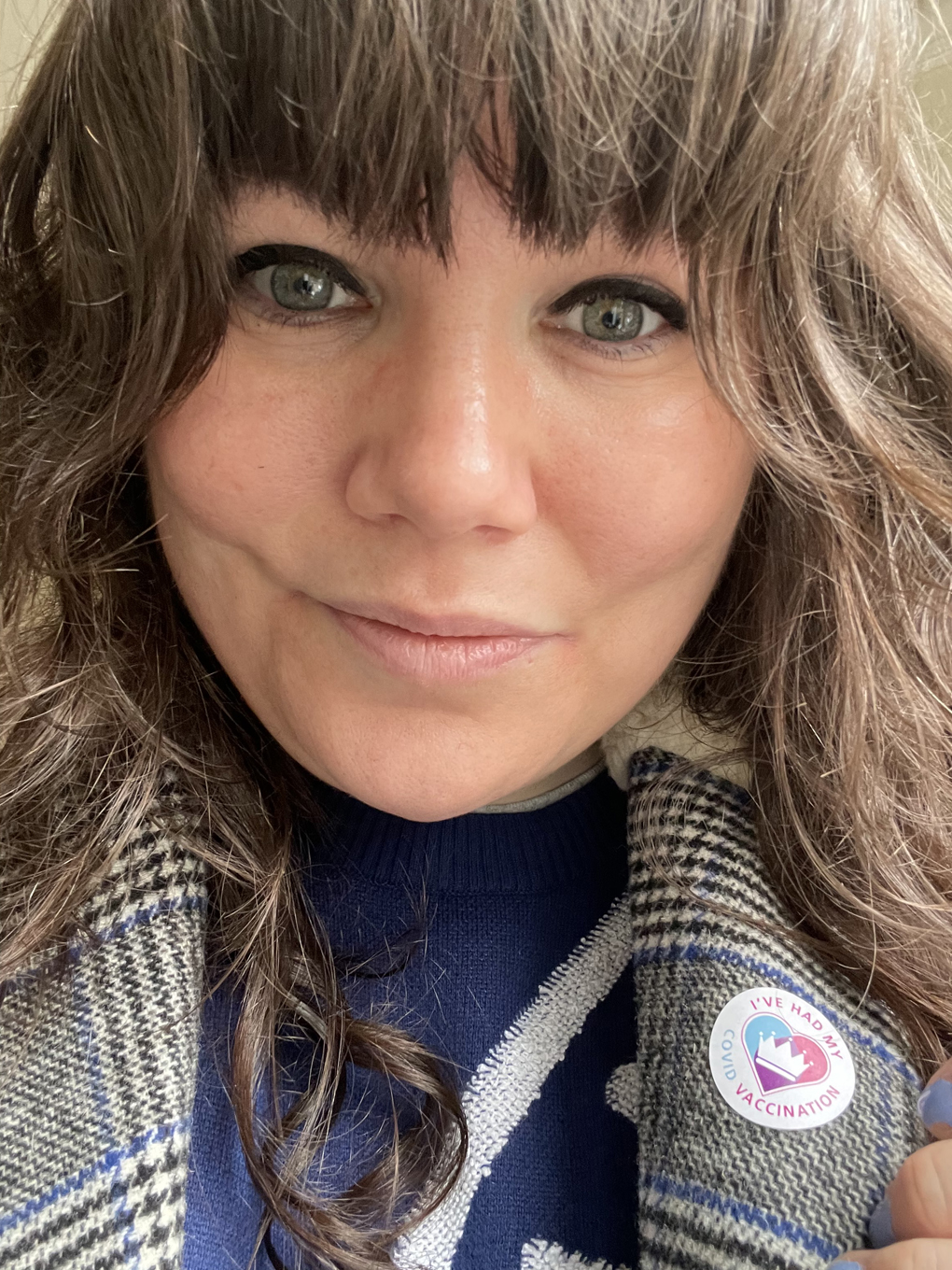 Woman with covid vaccine sticker.