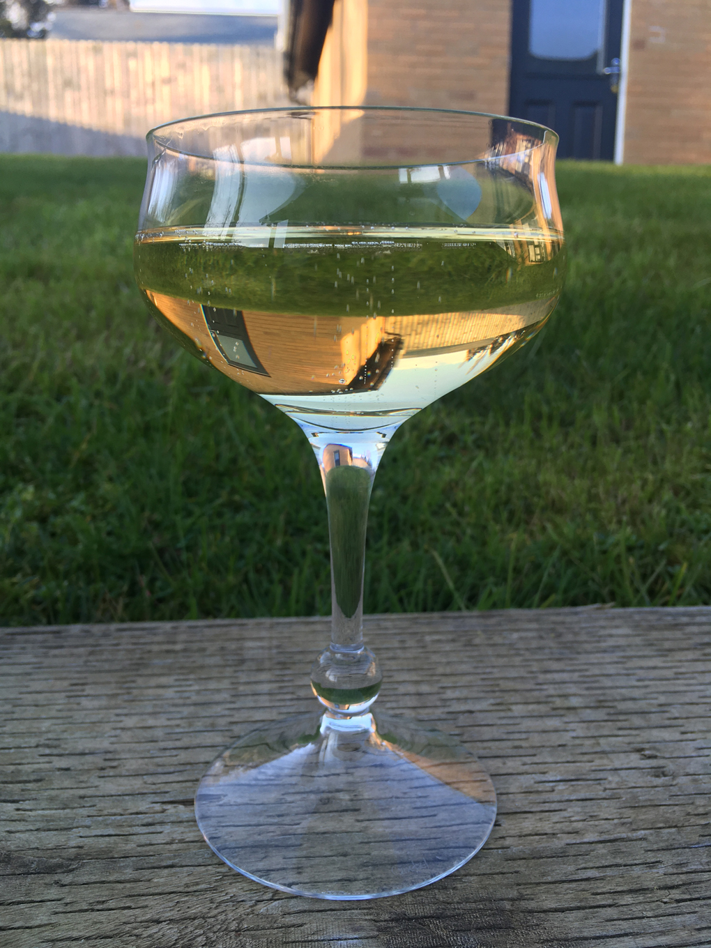 Glass of champagne with reflection of house in the liquid