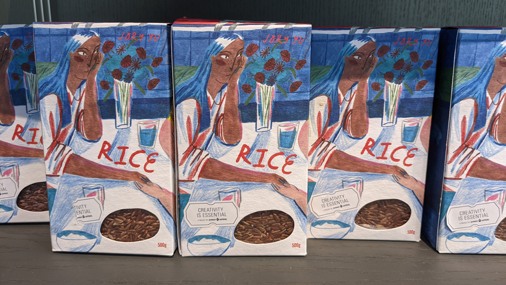 A box of rice featuring a painting of a woman at a table.