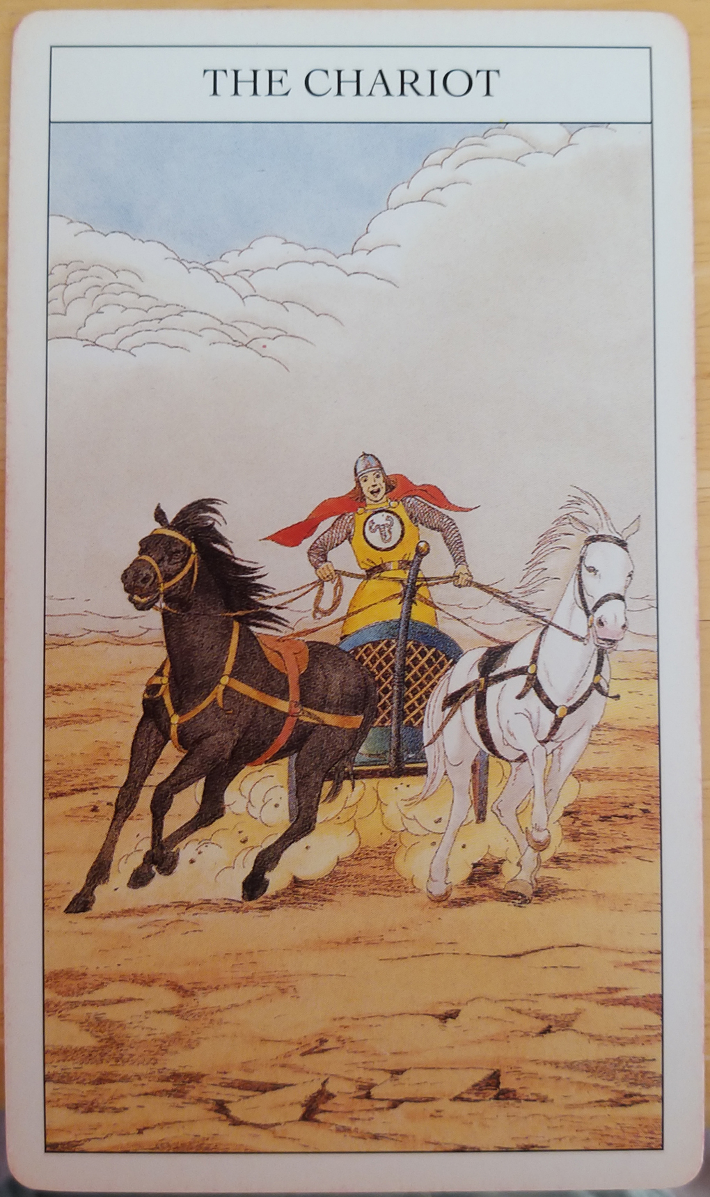 Tarot card depicting a charioteer in action, horses galloping through the desert
