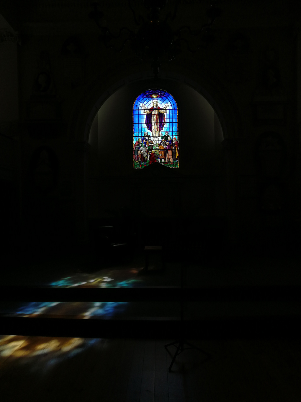stained glass window with sunlight creating a splash of colour on a stage