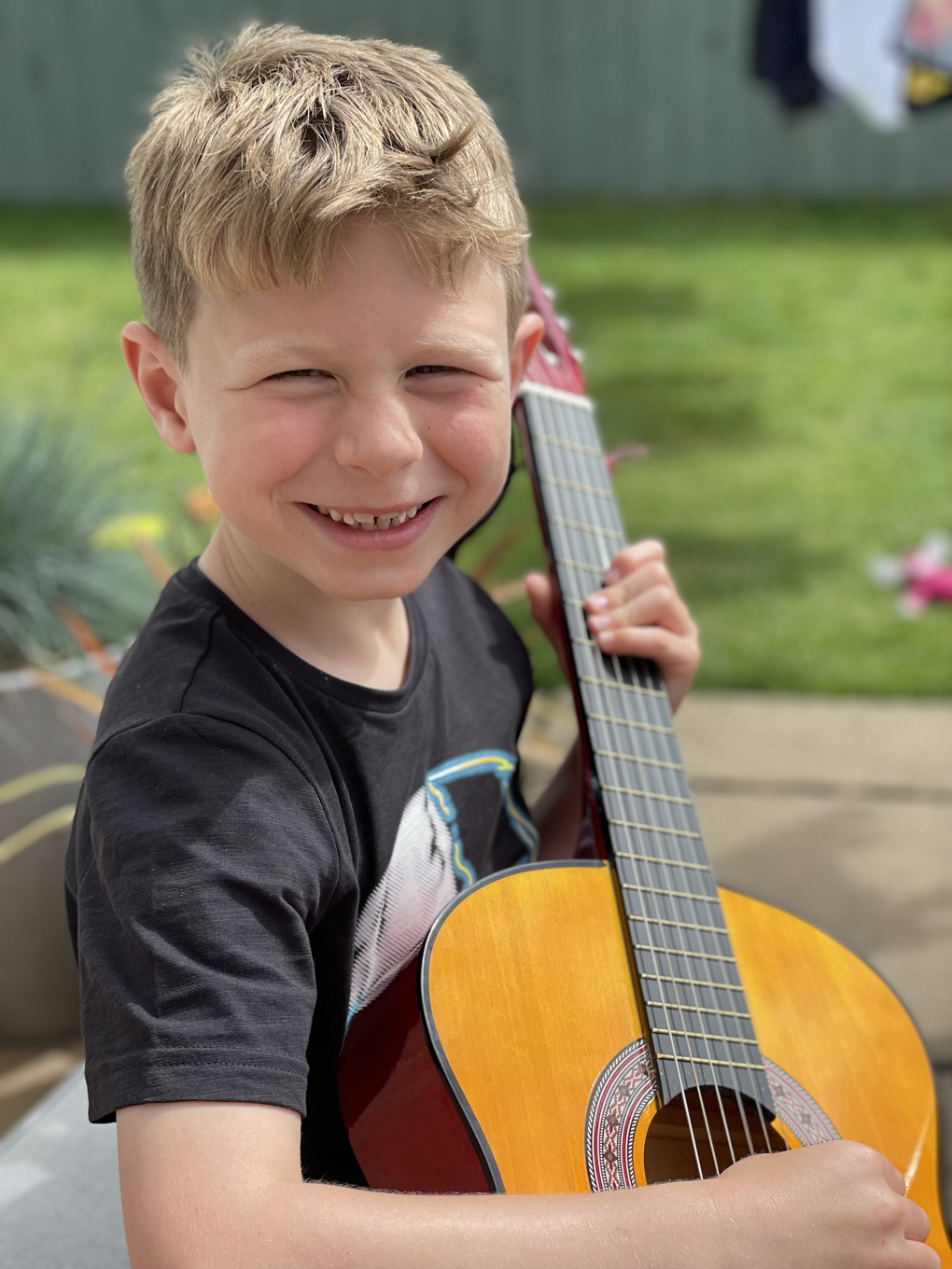 Picture of boy playing guitar in garden