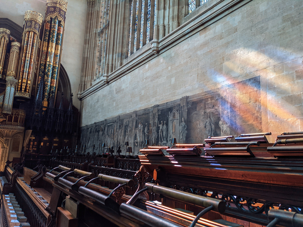 Light from stained glass window reflecting colours on wall inside chapel