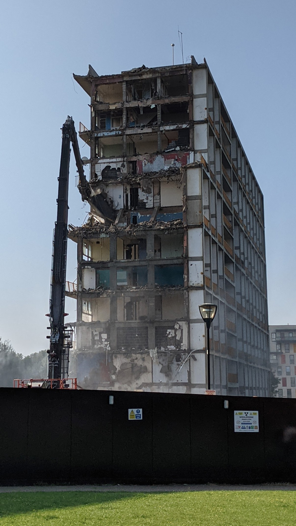 The block of flats, pictured in June's photograph, half-way through being demolished.