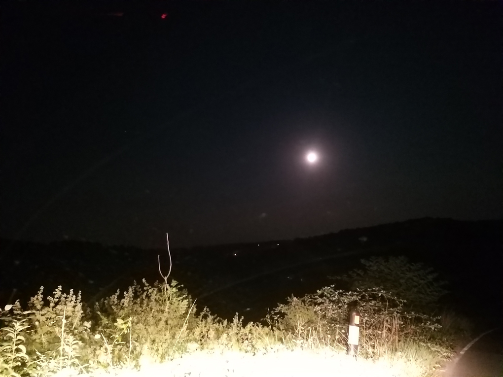 Full moon over a night-time view of the valley and hills.