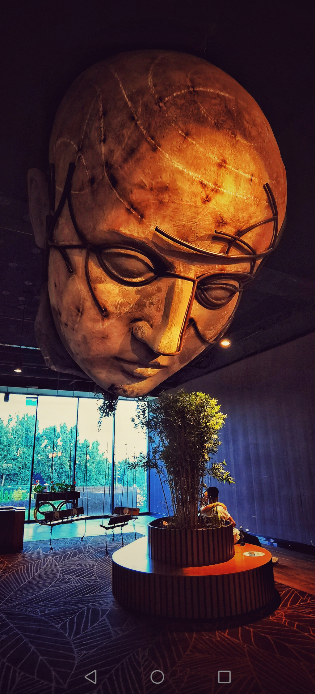 Artwork of large head on ceiling in a mall