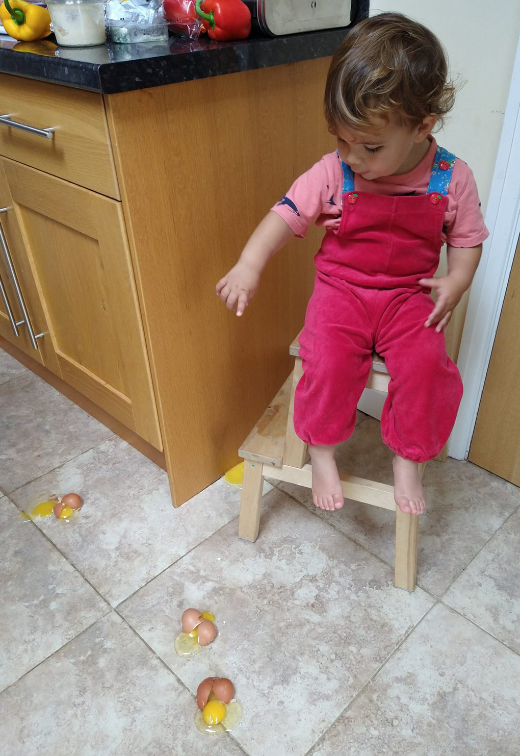 Toddler throwing eggs on the kitchen floor