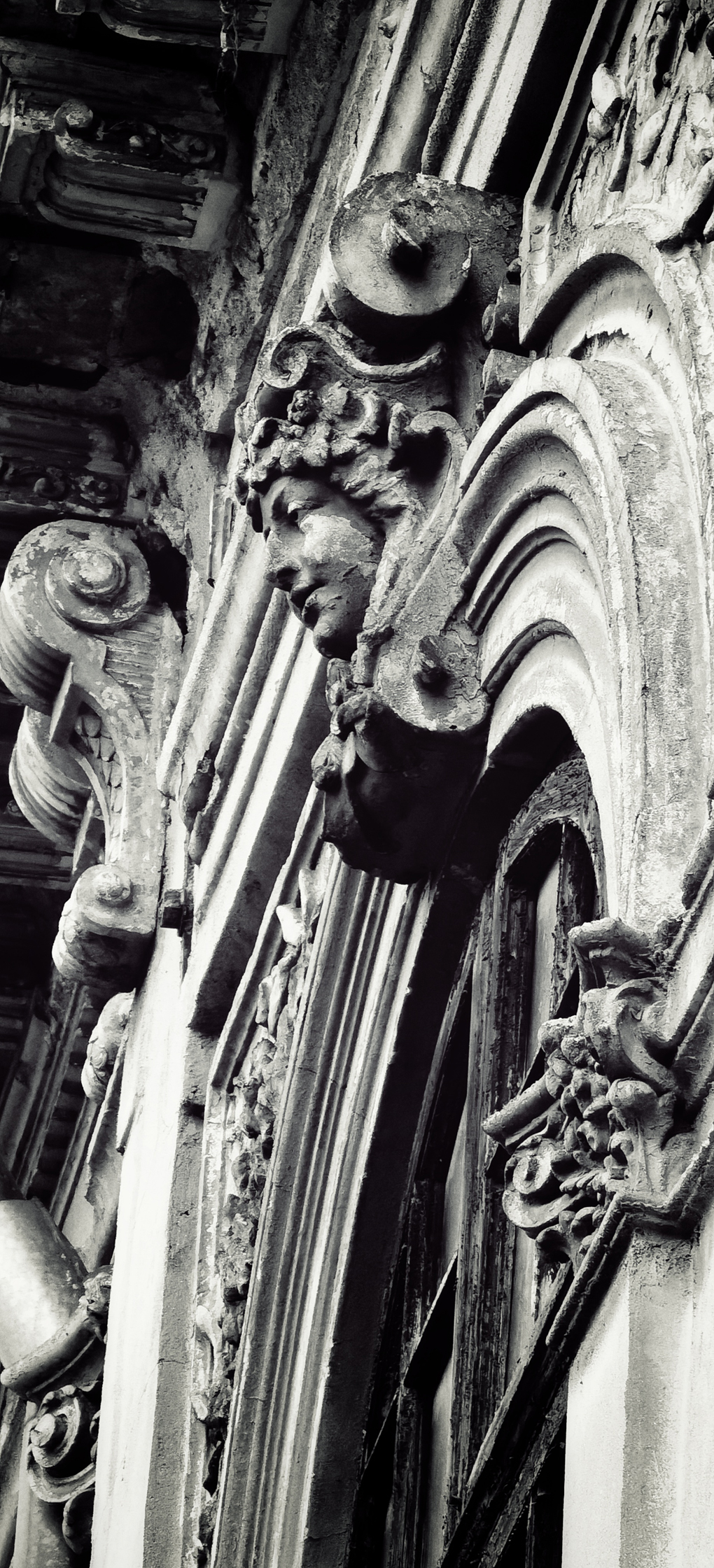 Stone head on arch on building in Bucharest