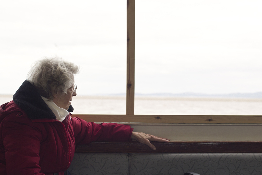 Elderly Lady overlooking the River Exe from a boat window.