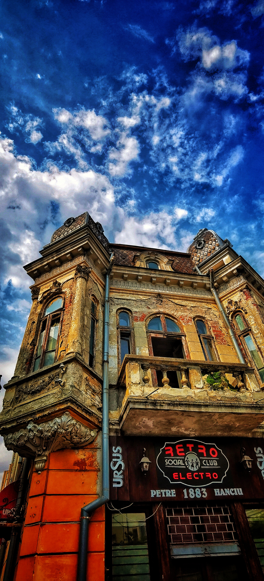 Historic building with modern front under blue sky with clouds