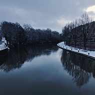 The a view from Victoria Bridge of the River Avon hemmed in by snow-laden paths.