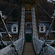 Crossing the Chain Bridge in Melrose, looking towards the Eilon hills with a dusting of snow