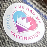Woman with covid vaccine sticker.