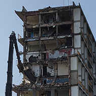 The block of flats, pictured in June's photograph, half-way through being demolished.