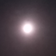 Full moon over a night-time view of the valley and hills.