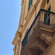 Looking up towards buildings, balconies and sky