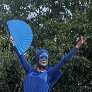 Dancers in long brightly coloured dresses on hoverboards and stilts