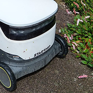 Boy looking at a white square wheeled robot