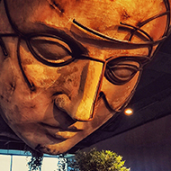 Artwork of large head on ceiling in a mall