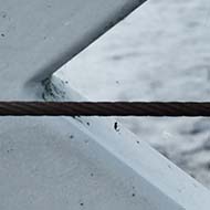 A square photo taken from a bridge over a river. The picture is dominated by a large steel cross, part of the bridge's construction.